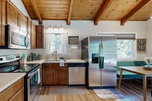 Una cocina con refrigerador de acero inoxidable y una mesa. en Green Abode, en Groveland