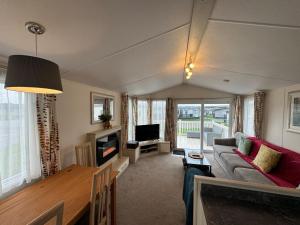 a living room with a couch and a tv at Northcott 59, Bude in Poughill