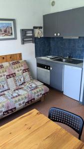 a small kitchen with a couch and a table in a room at Résidence Le Plein Soleil 2 - Studio 4 personnes, résidence Plein Soleil 2 à ORCIERES-MERLETTE, Alpes du Sud MAE-7574 in Orcières