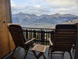two chairs sitting on a porch with a view of mountains at Studio Le Chamois - Veysonnaz in Veysonnaz +2 photos