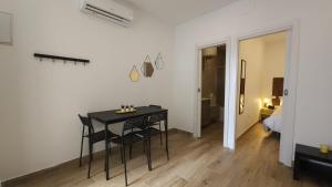 a black table and chairs in a room with a bedroom at M2 Loft Privado para 4 personas in Madrid