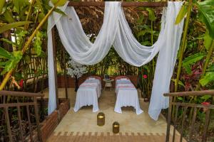 a tent with tables and chairs in a garden at NQ Hotel Orinoquia in Villavicencio