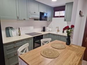 a kitchen with a wooden table with a vase of flowers at Ifach Calpe LUX Apartment in Calpe