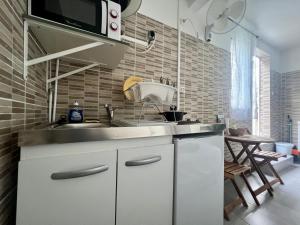 a kitchen with a sink and a microwave at Au pied de la Soufrière in Saint-Claude +21 photos
