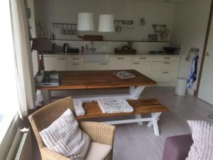 Una cocina con una mesa y dos sillas y una mesa. en Duinroos Home with Terrace, en Breskens