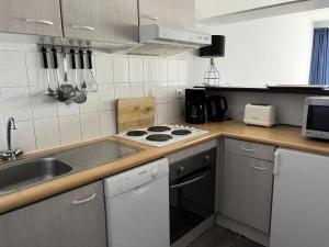 kuchnia ze zlewem i kuchenką górny piekarnik w obiekcie Résidence Balcons Du Soleil 1 - T2/6pers BALCONS DU SOLEIL 42- Peyresourde MAE-9394 w mieście Germ +2 zdjęcia