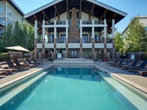 a swimming pool in front of a house with lounge chairs at Seasons at Sandpoint - Managed by Elite Alliance in Sandpoint
