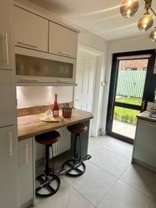 a kitchen with a counter and two bar stools at Royal Hillsborough Hideaway in Hillsborough