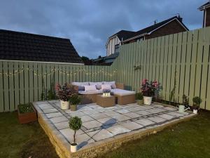 a patio with a couch and some plants and a fence at Royal Hillsborough Hideaway in Hillsborough
