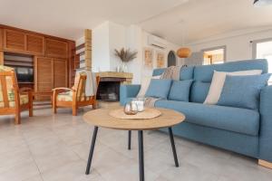 a living room with a blue couch and a table at Apartamento Blaucel in L'Escala
