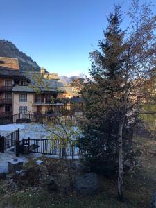 a pine tree in front of a fence at Arc 1950 - 2 bed ski-in ski-out with stunning views in Arc 1950
