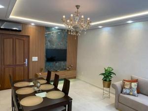 Appartement moderne avec vue panoramique في أغادير: غرفة معيشة مع طاولة طعام وثريا