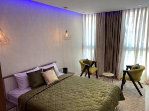 Appartement moderne avec vue panoramique في أغادير: غرفة نوم بها سرير وكراسي في الغرفة