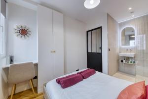 a bedroom with a white bed and a chair at L'audace T2 refait à neuf à Vanves in Vanves