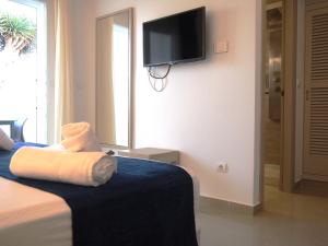 a hotel room with a bed and a tv on the wall at Hotel Roca Bella in Es Pujols