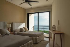 a bedroom with two beds and a large window at Sierra Mar in Isla Mujeres