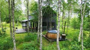 a house with a hot tub in the middle of a forest at Dom U Piepki in Zdunowice Małe