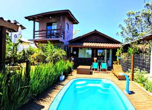 a house with a swimming pool in front of a house at Chalés Praia do Rosa piscina compartilhada in Imbituba +78 photos