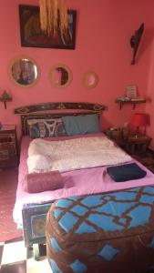 a bedroom with a large bed with pink walls at Dar Sam - Red Room in Rabat