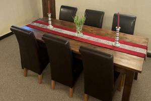 a wooden table with black chairs around it with a red stripe at Stunning cottage - 3 Bedrooms & 3 Bathrooms in Bakewell