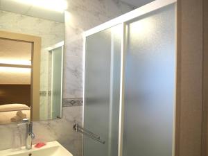 a shower with a glass door in a bathroom at Hotel Roca Bella in Es Pujols