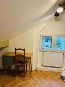 einen Holztisch mit Stuhl in einem Zimmer in der Unterkunft Grand Paris Cosy House in Vitry-sur-Seine