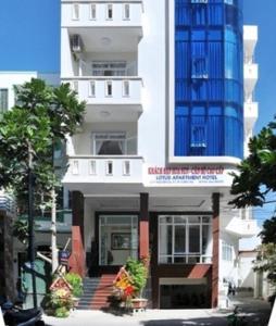 ein hohes weißes Gebäude mit einem blauen in der Unterkunft Lotus Apartment Hotel in Vũng Tàu