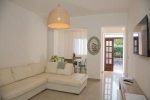 a living room with a white couch and a table at Le Floreali - Casa Salvia in Bolsena