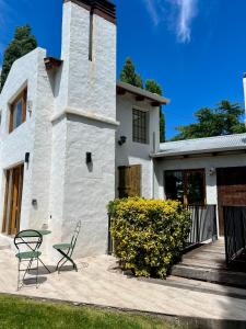 ein Haus mit einem Tisch und einem Stuhl davor in der Unterkunft Hospedaje Patagonia in Bahía Blanca