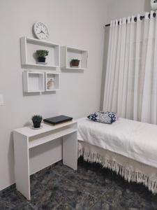a bedroom with a desk and a bed and a window at Casa Vanuze 2 in Holambra