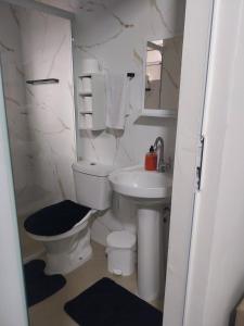a white bathroom with a toilet and a sink at Casa Vanuze 2 in Holambra