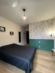 a bedroom with a bed and a large wall at Résidence des Carmes in Dol-de-Bretagne