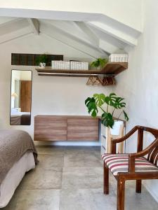 ein Schlafzimmer mit einem Bett, einem Spiegel und einem Stuhl in der Unterkunft Hospedaje Patagonia in Bahía Blanca + 19 Fotos