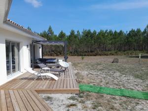 une terrasse en bois avec deux chaises et une table dans l'établissement Magnifique maison de plein pied, à Lesperon