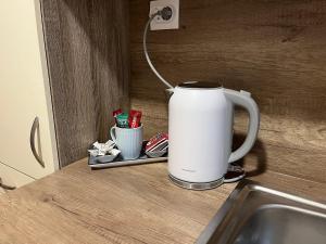 a white coffee mug sitting on a counter next to a sink at Sólyom Szálló in Szombathely