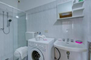 Un baño con lavadora y lavabo. en La Fresia - Focette 100m from sea - Happy Rentals, en Pietrasanta 24 fotos más