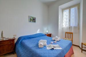 Un dormitorio con una cama azul con toallas. en La Fresia - Focette 100m from sea - Happy Rentals, en Pietrasanta