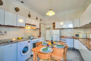 a kitchen with a table and a washing machine at Casa Vittoria 800m from sea - Happy Rentals in Forte dei Marmi