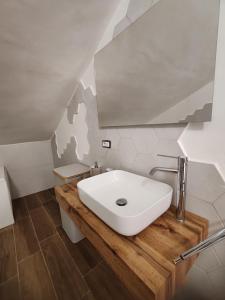 a bathroom with a white sink on a wooden counter at B&B Colli Ameni in Candela
