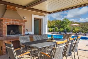 a patio with a table and chairs and a fireplace at Villa Vilani Spa & Pool - Happy Rentals in Crikvenica