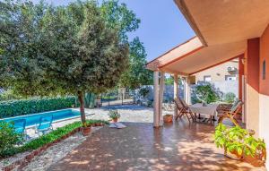a patio with a table and chairs next to a pool at 3 Bedroom Lovely Home In Barbariga in Barbariga +38 photos