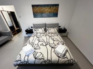 a bedroom with a bed with a black and white comforter at The One Malpensa Rooms in Vizzola Ticino