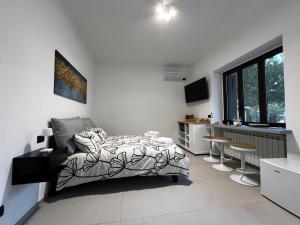 a bedroom with a bed and a kitchen with stools at The One Malpensa Rooms in Vizzola Ticino