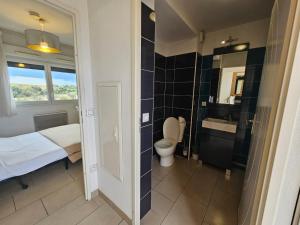 a bathroom with a bed and a toilet and a sink at 302 Studio Cosy sur Perpignan in Perpignan