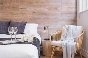 a bedroom with a bed with a chair and wine glasses at Cozy 1 bedroom apartment - Caulfield park in Melbourne