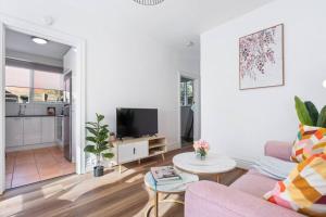 a living room with a pink couch and a table at Cozy 1 bedroom apartment - Caulfield park in Melbourne