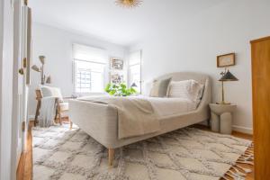 a white bedroom with a bed and a rug at Ivy Grace - 4 Br, Stylish, Pet-friendly Retreat in Indianapolis