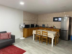 a kitchen with a table with chairs and a refrigerator at Zoe House in Paul do Mar