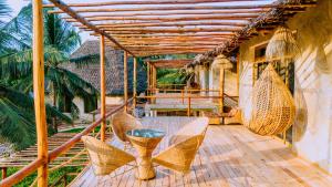 un patio con mesa y sillas de mimbre en Moyo Mzuri Villas Resort Zanzibar, en Migogoni