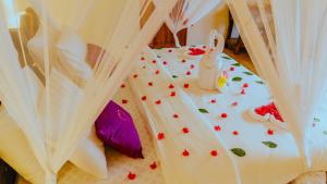 un pastel de boda con una cama con flores. en Moyo Mzuri Villas Resort Zanzibar, en Migogoni